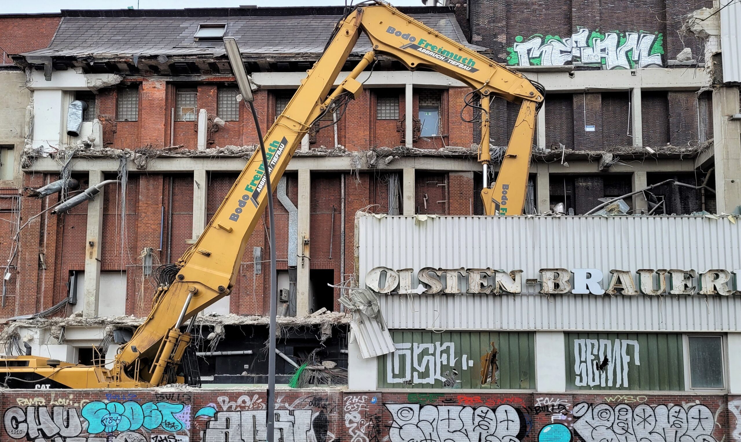 Bagger reißt Halle auf dem ehemaligen Holstengelände in Hamburg ab.